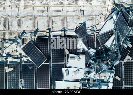 Zerbrochene Solarpaneele, die durch Hurrikan-Ian-Winde zerstört wurden, die auf dem Dach von Industriegebäuden zur Erzeugung von ökologischem Strom montiert sind. Stockfoto