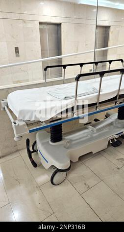 Leere Krankenliege und Rollstuhl, nachdem der Patient an der Operation im Operationssaal gestorben ist, bereit für den Transport von schweren Patienten Stockfoto