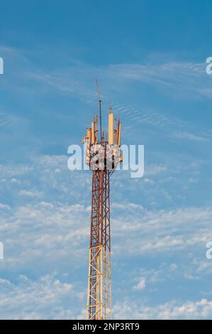 Funkturm der mobilen Kommunikation mit Antennen-Sendern vor dem Hintergrund des klaren Himmels Stockfoto