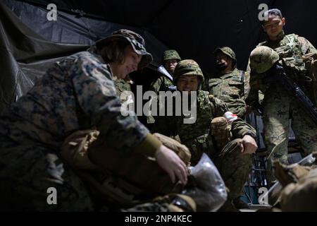 Hijudai, Japan. 18. Februar 2023. EIN US-AMERIKANISCHER Navy Corpsman mit der 31. Marine Expeditionary Unit, demonstriert den Soldaten mit dem Amphibien-Schnelleinsatzregime 1., Japan Ground Self-Defense Force, während einer Massenübung von Verletzten in Hijudai, Japan am Februar. 18, 2023. Das Training simulierte ein Massenunfallereignis, das dem beidseitigen medizinischen Team die Möglichkeit gab, während der Iron Fist 23 unter genau simulierten Druck und Bedingungen aktiv medizinische Versorgung vor Ort zu praktizieren. Iron Fist ist eine jährliche bilaterale Übung Stockfoto