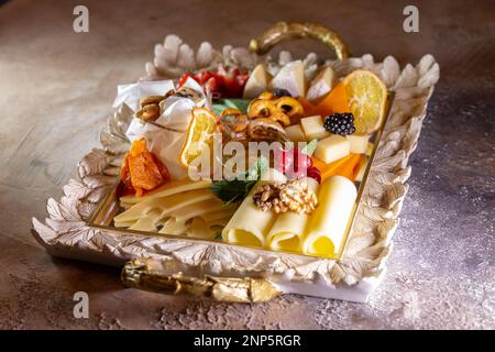 Gemischter Käse auf einem Tablett mit Nüssen und Honig. Stockfoto