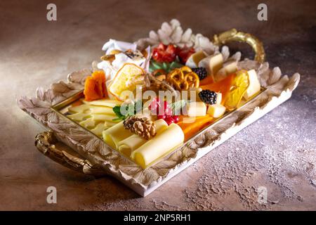 Gemischter Käse auf einem Tablett mit Nüssen und Honig. Stockfoto