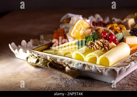 Gemischter Käse auf einem Tablett mit Nüssen und Honig. Stockfoto