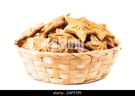 Sternförmige Kekse in einem Korb aus Korb, isoliert auf weißem Hintergrund. Shortbread. Lebkuchen-Keks. Hausgemachtes Backen. Stockfoto