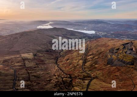 Luftbild einer Drohne mit Blick auf den Sonnenaufgang, Winterblick von Red Screes im Lake District mit Blick auf Windermere in der Ferne über Wansfell Pike Pea Stockfoto