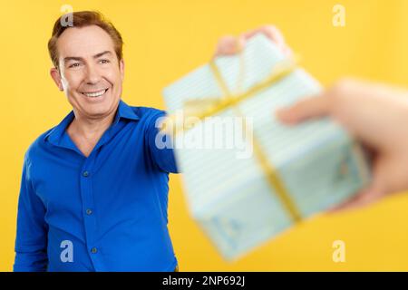 Ein erwachsener Mann, der ein Geschenk zum Vatertag erhält Stockfoto