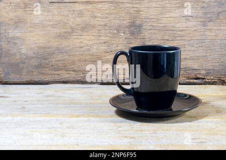 Hohe schwarze Keramik-Kaffeetasse auf Holzhintergrund Stockfoto