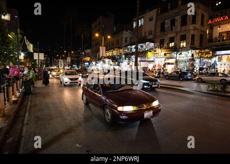 Amman, Jordanien - 23 2022. Oktober: King Faisal Street in Downtown Amman bei Nacht mit Verkehr Stockfoto