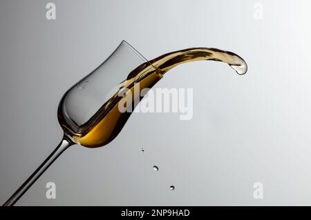 Das Getränk wird aus dem Glas verschüttet. Konzept des Themas Premium-Alkohol. Speicherplatz kopieren. Stockfoto