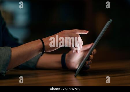 Männliche Hände berühren den PC-Bildschirm mit digitalem Pad und benutzen das Gerät nachts Stockfoto