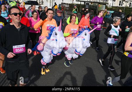 Brighton UK 26. . Februar 2023 - Ein Paar Einhörner als tausende Läufer nehmen an einem strahlenden Morgen an der Südküste am Brighton Halbmarathon 33. Teil . Über zehntausend Läufer sollen dabei helfen, Geld für verschiedene Wohltätigkeitsorganisationen zu sammeln: Credit Simon Dack / Alamy Live News Stockfoto