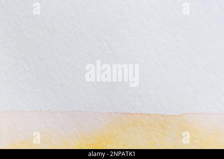Makro-Nahaufnahme einer gelben Aquarellfarbe auf einem strukturierten, weißen Aquarellpapier. Hochauflösender Vollformathintergrund mit Kopierbereich. Stockfoto