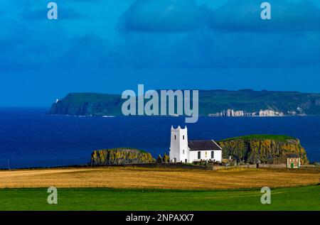 Ballintoy Church of Ireland mit Blick auf Rathlin Island an der Nordküste, County Antrim, Nordirland Stockfoto