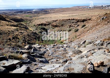 Blick von der Straße neben montana blanca in Richtung tias und arrecife Flughafen mit Schlucht erodiert durch Wasser Lanzarote, Kanarische Inseln, Spanien unfruchtbar außer Stockfoto