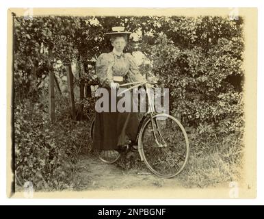 Originales viktorianisches Foto einer Frau mit ihrem Fahrrad in einem Garten, Oldtimer-Radfahren, um 1898, Großbritannien Stockfoto