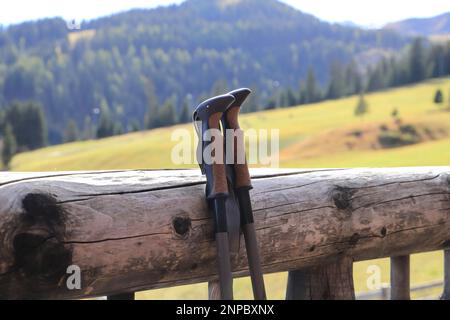 Zwei Wanderstöcke, die auf einem Geländer geparkt sind Stockfoto