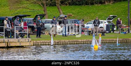 Mitglieder des Model Boat Club mit Modellyachten auf dem See in Warminster, Wiltshire, Großbritannien, am 26. Februar 2023 Stockfoto