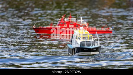 Nahaufnahme eines Modellbootes - Spitfire - auf dem Wasser mit rotem Modellboot im Hintergrund - Warminster, Wiltshire, Großbritannien am 26. Februar 2023 Stockfoto