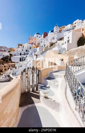 Berühmte griechisch-orthodoxe Kirche mit blauer Kuppel und Wohngebäuden auf der Insel Santorin. Stockfoto