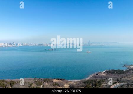 QINGDAO, CHINA - 26. FEBRUAR 2023 - Kreuzfahrtschiffe und Frachter fahren das Meer in Qingdao, Provinz Shandong, China, 26. Februar 2023. Stockfoto