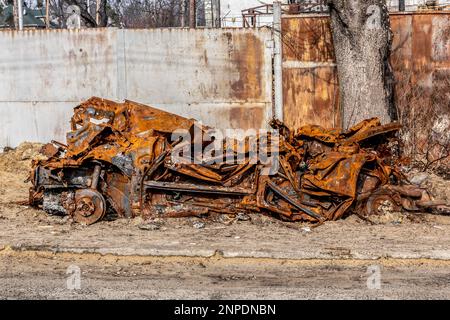 Irpin, Ukraine. 25. Februar 2023. Ein verbranntes Auto wurde auf der Straße in Irpin gesehen. Irpin wurde während der ersten Monate der russischen Invasion der Ukraine besetzt, und viele Wohngebäude wie dieses wurden während der Kämpfe bombardiert und erschossen. Mutig beim Wiederaufbau ist eine der ukrainischen NRO, die Freiwillige für Reparaturarbeiten engagieren. Da die massive Invasion der Ukraine durch die russischen Streitkräfte ihren ersten Jahrestag vergeht, gibt es viele Gebäude in der Kiew-Region, die noch neu aufgebaut werden müssen, da das Ausmaß der Zerstörung enorm war. Kredit: SOPA Images Limited/Alamy Live News Stockfoto