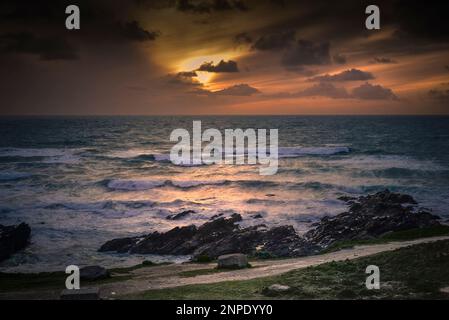 Ein spektakulärer Sonnenuntergang über der Fistral Bay in Newquay in Cornwall in Großbritannien. Stockfoto