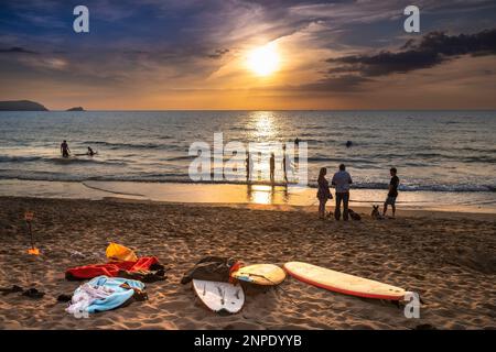 Urlauber genießen einen spektakulären Sonnenuntergang über der Fistral Bay in Newquay in Cornwall in Großbritannien in Europa. Stockfoto