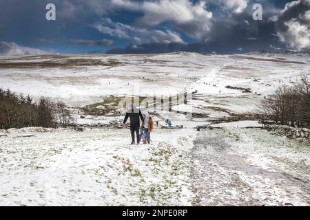 Menschen, die gerne im Schnee auf dem wilden rauen Tor am Bodmin Moor in Cornwall spazieren gehen. Stockfoto