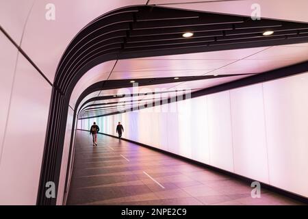 Zwei Männer passieren einander im Kings Cross Light Tunnel, der den internationalen Bahnhof mit der Londoner U-Bahn verbindet. Stockfoto