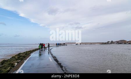 Familien, die am Neujahrstag am Marine Lake in West Kirby spazieren gehen. Stockfoto