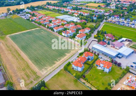 Wohnhäuser im Frühling aus der Vogelperspektive. Ein Foto von der Nachbarschaft, Vorort. Immobilien, Drohnenaufnahmen, Sonnenuntergang, Sonnenlicht, von oben. Stockfoto