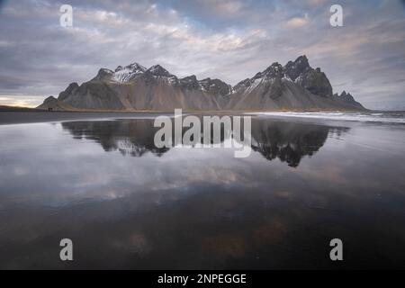 Der Vestrahorn-Berg spiegelt sich im nassen Sand wider. Stockfoto