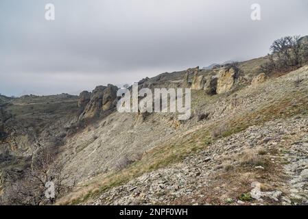 Lebkuchenpferd und bizarre Felsen in Dead City. Khoba-Tele Ridge des Karadag Reservats im Frühling. Krim Stockfoto