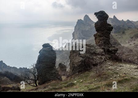 Lebkuchenpferd und bizarre Felsen in Dead City. Khoba-Tele Ridge des Karadag Reservats im Frühling. Krim Stockfoto