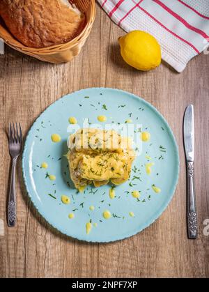 Traditionelle griechische Kohlrollen (Lahanodolmades) mit Rinderhack, Reis und Sahne Sauce auf einem Holztisch Stockfoto