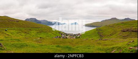 Stykki, Färöer - Juli 2021: Blick von oben auf das charmante kleine Dorf, eingebettet in ein Tal mit Blick auf den Atlantischen Ozean. Kvívík (Dänisch: Kvivig) Stockfoto