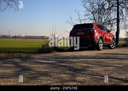 Roter Jeep am Straßenrand neben einem Feld in italienischer Landschaft Stockfoto