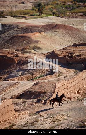 Mann auf einem Pferd in der Wüste von Ait ben haddou, Marokko, 5. Dezember 2018 Stockfoto