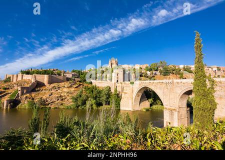 Blick auf die San Martin Brücke, die den Tejo überquert, um die Altstadt von Toledo auf dem Hügel zu betreten, wo Sie die alte Kathedrale sehen Stockfoto