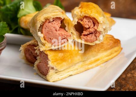 frankfurter in Blätterteig mit Salat Stockfoto