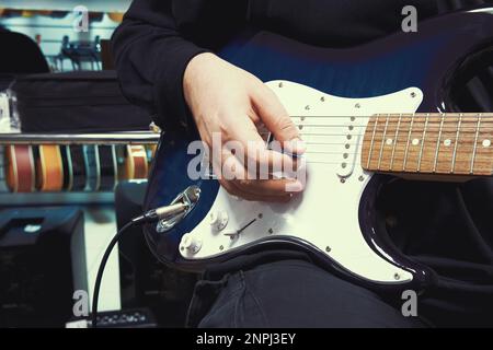 Ein Mann spielt Gitarre. Die Hand eines männlichen Gitarrist, der elektrische Gitarrennaht spielt Stockfoto