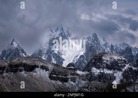 Die felsigen Gipfel des Berges Cadini di Misurina, teilweise von Wolken umhüllt und mit frischem Schnee bedeckt. Stockfoto