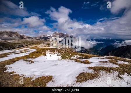 Gipfel der Sexten Dolomiten, der Berg Zwölferkofel in der Mitte, die Stadt Auronzo im Tal, teilweise von Wolken umhüllt, mit frischem Schnee bedeckt. Stockfoto