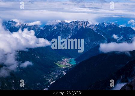 Die Stadt Auronzo di Cadore, am See Lago di Santa Caterina gelegen, umgibt die Berge der Sexten Dolomiten, teilweise von Wolken umhüllt. Stockfoto