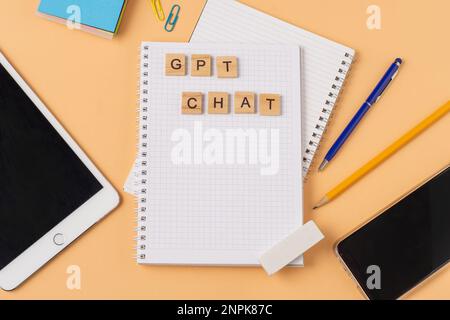 Arbeits- und Studienhintergrund mit Hilfe eines ChatGPT-bot. Wörter in Holzbuchstaben. Tischansicht mit freiem Notizbuchbereich. Chat-GPT zum Arbeiten und Erstellen. Ukraine, Kiew - 21. Februar 2023 Stockfoto
