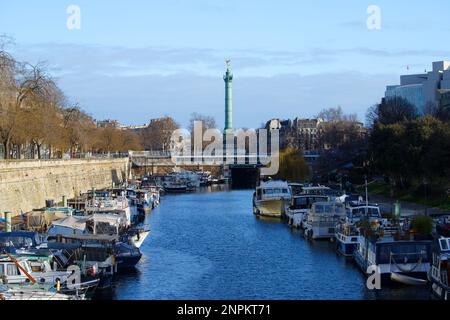 Die Bastille-Juli-Kolumne und Boote, die im Hafen von Arsenal auf dem Canal Saint Martin, Paris, Frankreich, anlegen. Stockfoto