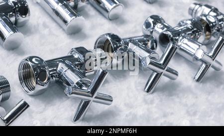 Absperrarmaturen verchromt mit kreuzförmigem Griff zum Verbinden und Schließen von Wasserrohren Stockfoto