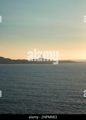 Turm des Herkules am Horizont, beleuchtet von den letzten Sonnenstrahlen bei Sonnenuntergang. Gelegen in Einem Coruña, Galicien, und von historischem Interesse, Kopie s Stockfoto