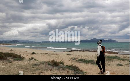 Santa Margalida, Spanien. 26. Februar 2023. Eine Frau geht spazieren in Can Picafort. In den nächsten Tagen wird mit Regenwetter und sinkenden Temperaturen gerechnet. Kredit: Clara Margais/dpa/Alamy Live News Stockfoto