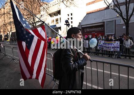 New York, New York, USA. 24. Februar 2023. Ein einsamer Demonstrant hält eine amerikanische Flagge vor einer organisierten Drag Story Hour in einer Queens Library. In den letzten Kulturkriegen haben sich Demonstranten in diesen Märchenstunden im ganzen Land beschuldigt, dass Organisatoren Kinder "pflegen". (Kreditbild: © Laura Brett/ZUMA Press Wire) NUR REDAKTIONELLE VERWENDUNG! Nicht für den kommerziellen GEBRAUCH! Stockfoto